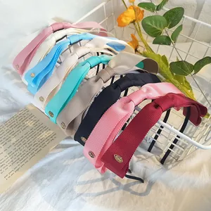 Détail de serre-têtes en ruban gros-grain multicolore avec pendentifs dorés