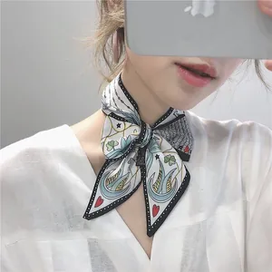 Macro shot of a French silk twilly scarf with bird and clover prints tied on a neck