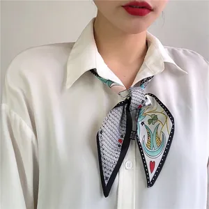 Detail of silk hair scarf with colorful tarot symbols tied on a white shirt collar