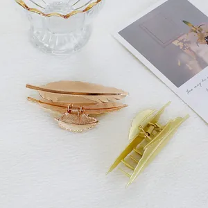 Dettaglio dei fermagli per capelli a foglia con finiture in oro e oro rosa lucido