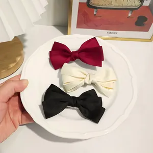 Three-piece set of elegant satin bow hair clips in red, cream white, and black colors