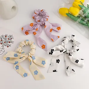 Floral print bow scrunchies set in purple, yellow, and white with long flowing ribbons