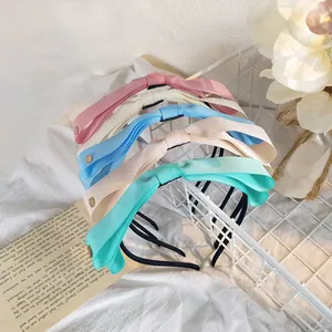Détail de cinq serre-têtes à double nœud couleur bonbon en ruban gros-grain texturé
