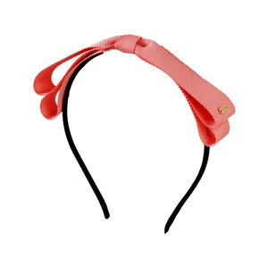 Serre-tête fin noir avec un nœud en ruban gros-grain rouge corail et détail doré