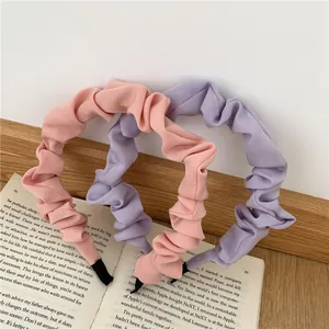 Detailed view of pink and purple pleated fabric headbands styled on vintage books