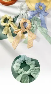 Detailopname van chiffon haarelastiekjes met stippen en lange linten in pastelkleuren