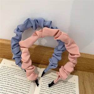 Detail of ruffle fabric headbands in pink and blue, set of two on vintage book