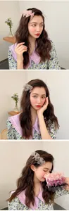 Detailed view of 3D layered lace flower hair clips in pink and pastel purple mesh