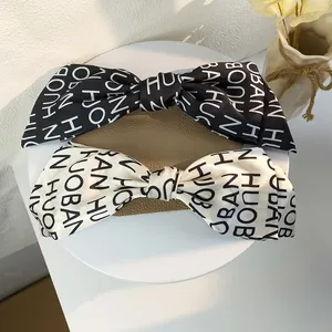 Large French vintage bow hair clip with contrasting letters on satin in black and white