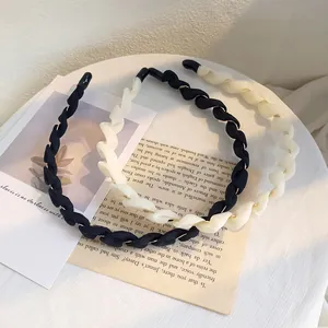 Dettaglio di cerchietti in tessuto intrecciato nero e crema su carta vintage
