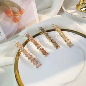 Elegant beaded hair clips with rhinestones in four colors on a white ceramic plate
