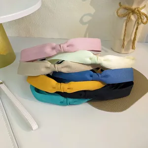 Empilement de serre-têtes en tissu multicolore aux couleurs pastel avec nœud doux