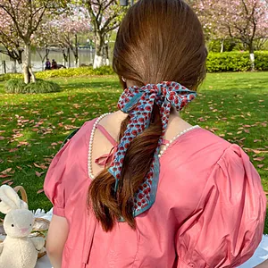 Close-up of floral hair ribbon tied on a pink dress with elegant pearl detailing