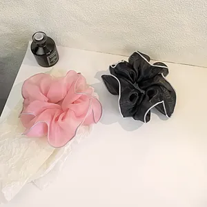 Detail of pink and black organza hair scrunchies with elegant ruffled edges