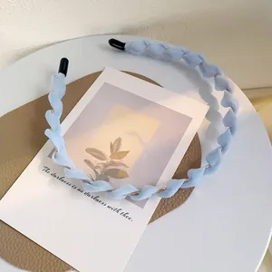 Dettaglio del cerchietto intrecciato in chiffon azzurro con struttura in metallo dorato