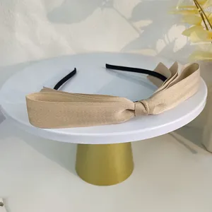 Détail d'un serre-tête élégant à gros nœud champagne avec ruban côtelé multicouche chic