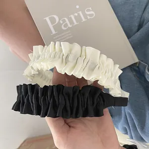 Detail of French vintage pleated wide headbands in black and beige with striped texture