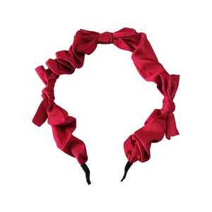 Elegant deep red satin pleated headband featuring a silk bow design on white background