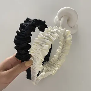Detail of pleated fabric texture on French vintage wide headbands in black and cream white