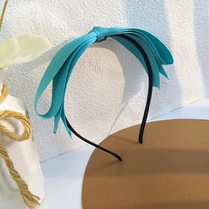Gros plan du serre-tête bleu tiffany avec un grand noeud multicouche en ruban côtelé