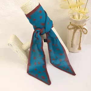 Close-up of lightweight navy blue chiffon scarf with red polka dots and pointed edges