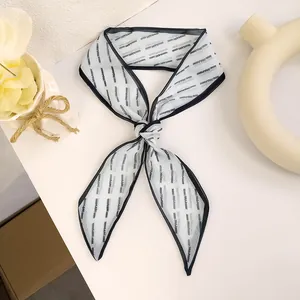 Close-up of lightweight chiffon hair scarf with elegant bow knot and blue oblique pattern