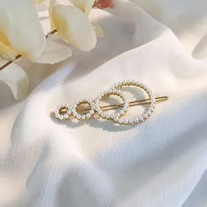 Close-up of golden pearl hair clip featuring overlapping circles with white pearls
