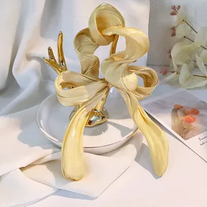 Macro di elastico per capelli in raso champagne con texture setosa e pieghe dettagliate