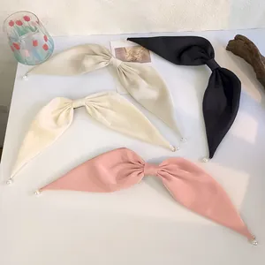 Vue détaillée de grandes barrettes nœud en satin avec perles en quatre couleurs