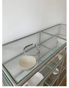Detailansicht eines silbernen Kettenstirnbandes auf einem minimalistischen Regal