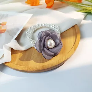 Close-up of double-layered pearl hair tie with a delicate grey-purple satin rose detail