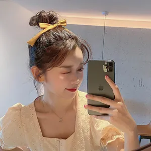 Elegant bright yellow bow hair clip hair tie styled on a person for a sweet aesthetic look