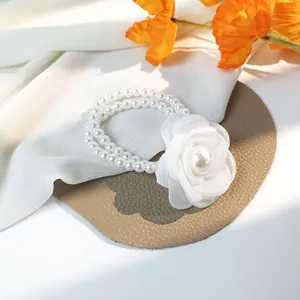 Elegant double-layer pearl flower hair tie with white fabric rose on silk background