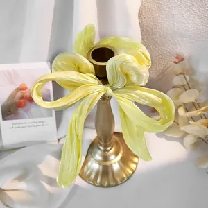 Dettaglio di un elastico per capelli a fiocco in raso giallo tenue con trama setosa