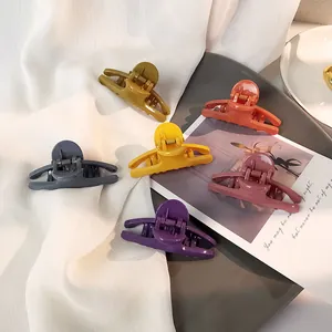 Detail view of colorful glossy medium hair claws set on a minimalist background