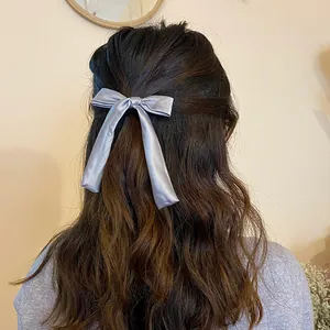 Elegant silver-grey satin bow hair tie with long ribbons on a half-up hairstyle