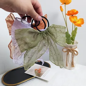 Detailed view of layered organza bow scrunchies with wavy edges in three elegant colors