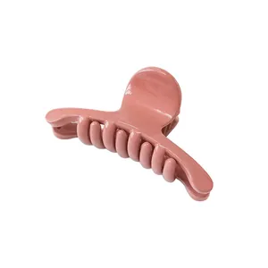 Minimalist pink matte hair claw clip shown from a 45-degree angle on a white background