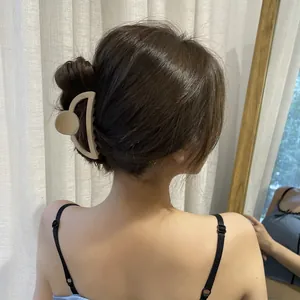 Detailed view of a matte beige shark hair clip securing a hair bun for a soft look