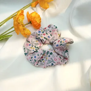 Vue détaillée d'un chouchou floral avec fond rose et motifs de fleurs éclatantes