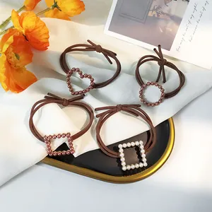 Set of four vintage pearl elastic hair ties with heart and geometric charms on silk fabric