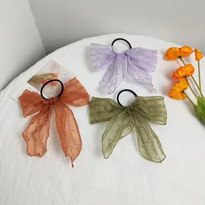Detailed view of three lace hair ties with Love is Love print in purple and green