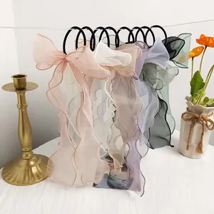 Set of six organza bow hair scrunchies with long ribbons and wavy edges in pastel colors