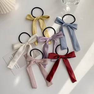 Detail showing a 6-piece set of silk bow hair scrunchies in various Morandi colors