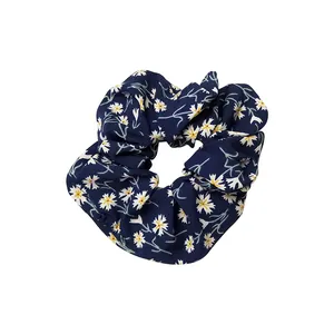 Chouchou bleu marine à motif de marguerites avec texture en tissu doux et plissé