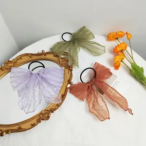 Three-pack organza lace bow scrunchies in green, purple, and caramel for hair and bags