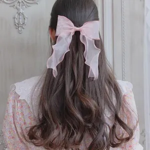 Detailed back view of pink organza bow hair tie with ribbons on long wavy hair