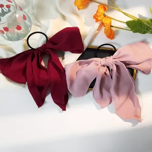 Detail von Chiffon-Haarschleifen in Burgund und Rosa mit eleganten langen Bändern