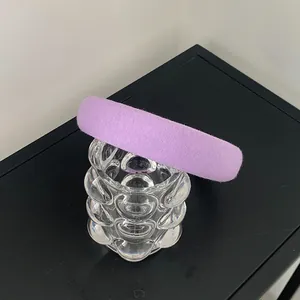 Close-up of padded purple headband with soft fabric texture on glass surface