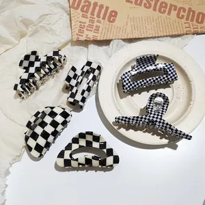 Detailed set of five black and white checkered acetate hair claws in various geometric shapes